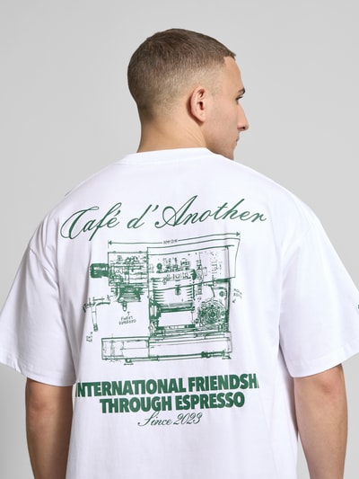Männermodel trägt Regular Fit T-Shirt mit Logo-Print von ANOTHER COTTON LAB aus Baumwoll-Mix, Weiß mit grünem Print, Ganzkörperansicht Rückansicht.