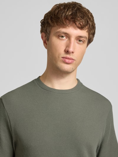 Männermodel trägt Regular Fit T-Shirt aus Baumwoll-Mix Modell 'TOBIE' von Only & Sons, einfarbig mit Waffel-Struktur, Nahaufnahme Oberkörper.