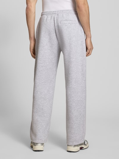Männermodel trägt Sweatpants mit elastischem Bund von REVIEW in Hellgrau, Relaxed-Fit, Gesäßtasche, Material-Mix, Ganzkörperansicht Rückansicht.