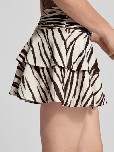 Frauenmodel trägt Minirock aus Viskose-Mix im Stufen-Look von Gina Tricot, Allover-Look, A-Linie, Elastischer Bund, Nahaufnahme Oberschenkel.