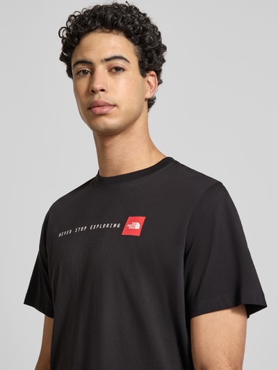Männermodel trägt Regular Fit T-Shirt mit Logo-Print van The North Face in zwart katoenmix, ronde hals, logo op borst, Nahaufnahme Oberkörper.