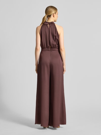 Modelka nosi Jumpsuit mit Zierschleife von Swing w kolorze śliwkowym, strukturalny wzór, dopasowany krój, bez rękawów, widok całej sylwetki z tyłu.