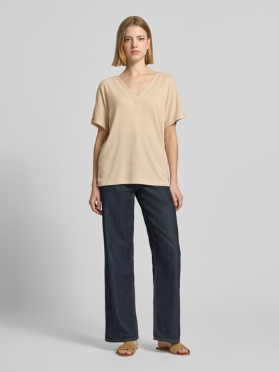 Frauenmodel trägt Strickshirt mit V-Ausschnitt Modell 'Delia' von Soyaconcept Damen, aus Viskose-Mix mit Stretch-Anteil, Relaxed-Fit, beige Farbe, Rückenlänge bei Größe S 60 cm, Ganzkörperansicht von vorne.