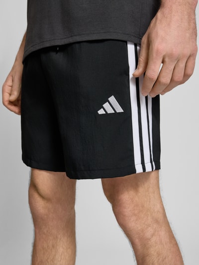Männermodel trägt schwarze Herren Shorts von adidas Sportswear, Modell '3S CHELSEA', Optik: Unifarben, Nahaufnahme Oberschenkel.