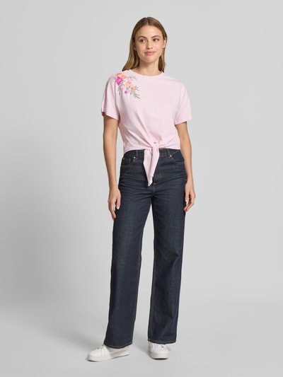 Frauenmodel trägt Damen T-Shirt aus Reine Baumwolle, Regular-Fit, Modell 'Fabian' von YAS mit floralem Stitching und Zierknoten, Ganzkörperansicht von vorne. Rückenlänge bei Größe S: 47 cm.