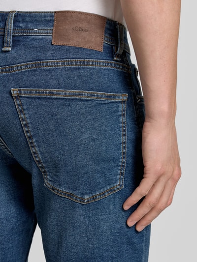 Männermodel trägt Regular Fit Jeans-Bermudas aus Baumwoll-Mix von s.Oliver RED LABEL, 5-Pocket-Design, Kontrastnähte, Nahaufnahme Rückansicht.