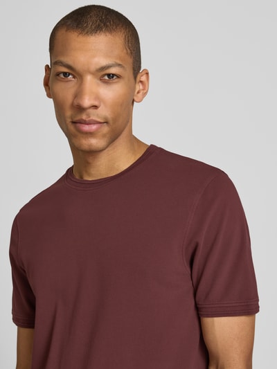 Männermodel trägt Regular Fit T-Shirt mit Rundhalsausschnitt Modell 'Lao' von CINQUE aus elastischem Baumwoll-Mix in Dunkelrot, Nahaufnahme Oberkörper.