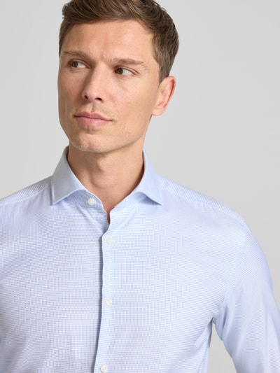 Männermodel trägt Slim Fit Businesshemd aus reiner Baumwolle Modell 'HANK' von BOSS, Allover-Muster, Haifischkragen, Nahaufnahme Oberkörper.
