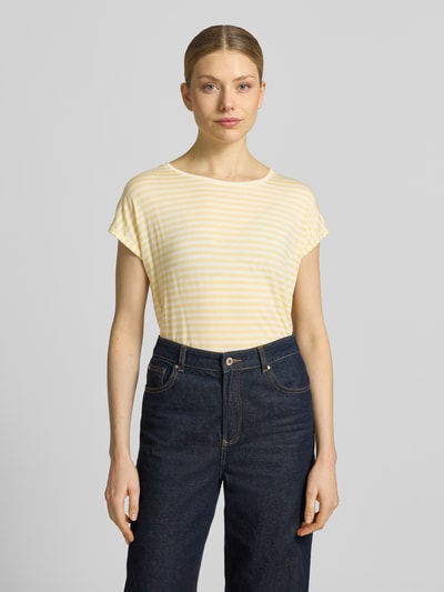 Frauenmodel trägt Relaxed Fit T-Shirt aus Lyocell-Mix Modell 'AVA' von Vero Moda mit Optik:Allover-Muster, gestreift, Rundhals, Kurzarm, fixierter Umschlag, sanfte Gelb-Weiß-Töne, feine weiche Textur, Ganzkörperansicht von vorne.
