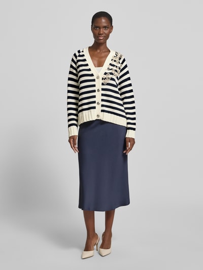Frauenmodel trägt Relaxed Fit Cardigan mit Ziersteinbesatz von Liu Jo White in Schwarz-Weiß mit floralen Zierbesätzen und Strick-Optik, V-Ausschnitt, Knopfleiste, elastische Abschlüsse, Baumwoll-Mix, Ganzkörperansicht von vorne.