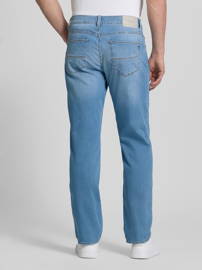 Männermodel trägt Regular Fit Jeans aus Baumwoll-Mix Modell 'CADIZ' von Brax, Denim-Optik, hellblaue Farbe, 5-Pocket-Design, Ganzkörperansicht Rückansicht.