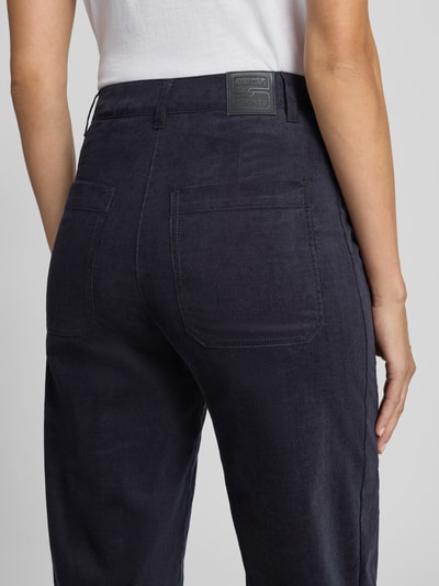 Frauenmodel trägt Straight Fit Hose aus Baumwoll-Mix von Marc Cain in dunkelblau, Cord-Optik, Eingriff- und Gesäßtaschen, Detailaufnahme Rückansicht.