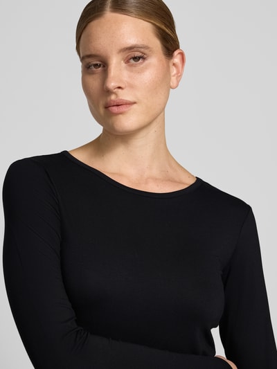 Frauenmodel trägt Longsleeve aus Viskose-Elasthan-Mix Modell 'Liana' von FREE/QUENT in Schwarz, glatte Textur, Nahaufnahme Oberkörper. Damen Longsleeve, Slim Fit, Rundhalsausschnitt, Rückenlänge bei Größe S 59 cm.