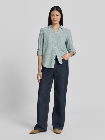 Frauenmodel trägt Regular Fit Hemdbluse aus reiner Baumwolle von Tom Tailor mit Hahnentritt Allover-Muster in mintgrün, Ganzkörperansicht von vorne.
