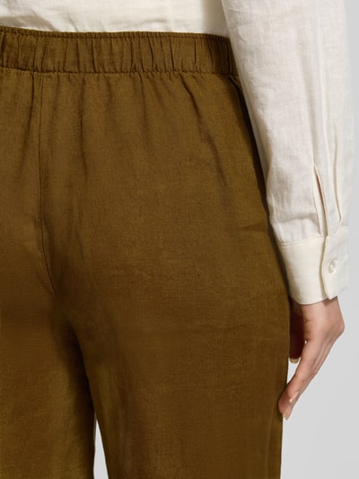 Frauenmodel trägt Leinenhose mit elastischem Bund Modell 'LINO' von Mango aus Reinen Leinen, Relaxed-Fit, Detailaufnahme Rückansicht.