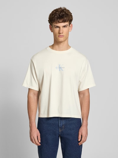 Männermodel trägt Relaxed Fit T-Shirt aus reiner Baumwolle von Calvin Klein Jeans in Optik: Unifarben, Label-Print, Ganzkörperansicht von vorne.