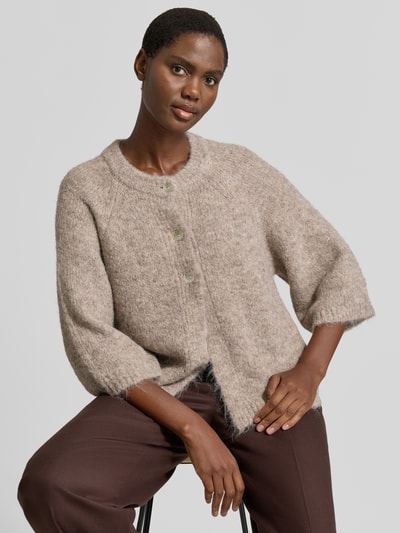 Vrouwenmodel draagt Relaxed Fit Cardigan met wol Model 'Lulu' van FREE/QUENT, elastische wolmix, tricotlook, 3/4-mouw, ruglengte 59 cm, mouwlengte 48 cm, kleur beige, zachte textuur, voorkant bovenlichaam, half close-up.