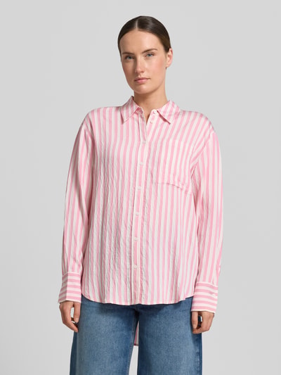Frauenmodel trägt Relaxed Fit Bluse aus Viskose-Mix von Comma, rosa-weiß gestreift, Hemdblusenkragen, Knopfleiste, Ganzkörperansicht von vorne. Rückenlänge bei Größe 36: 76 cm, Ärmellänge bei Größe 36: 57 cm.