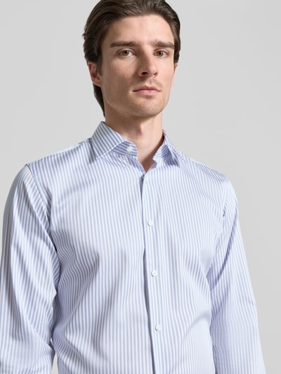 Männermodel trägt Regular Fit Businesshemd aus reiner Baumwolle Modell 'JOE' von BOSS mit blauen Streifen, Nahaufnahme Oberkörper.