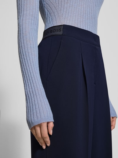 Frauenmodel trägt dunkelblaue Hose mit Bügelfalten Modell 'WILLOW O' von Raffaello Rossi, Regular Fit, Eingrifftaschen, Nahaufnahme Oberkörper, Bundweite bei Größe 36: 40 cm, Innenbeinlänge 85 cm.