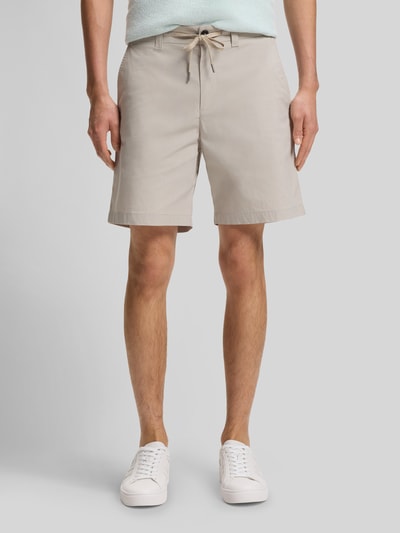 Männermodel trägt Regular Fit Chino-Shorts aus Baumwoll-Mix von BOSS Orange, Optik: Unifarben, Label-Applikation, Ganzkörperansicht von vorne.