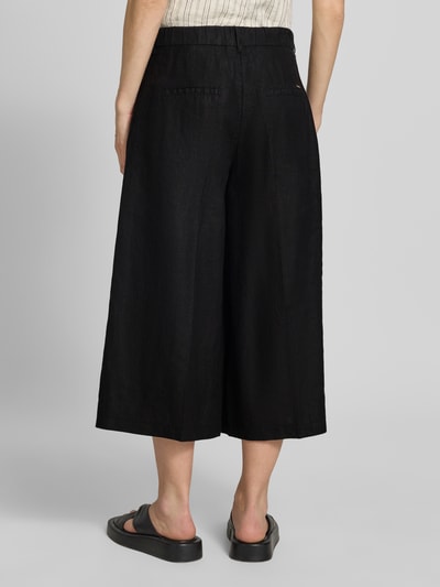 Frauenmodel trägt Loose Fit Leinenhose mit elastischem Bund Modell 'MELLI' von Brax, Unifarben, Cropped, seitliche Eingrifftaschen, reine Leinen, Ganzkörperansicht Rückansicht.