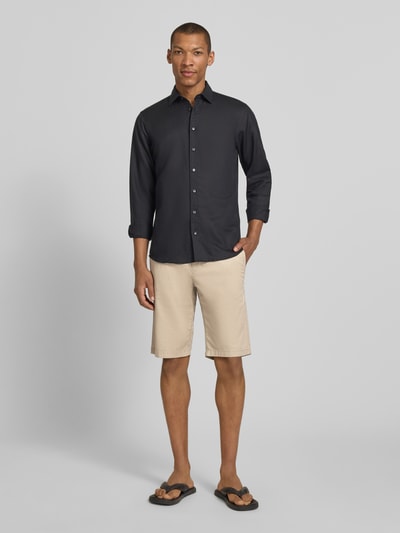 Männermodel trägt Slim Fit Chinoshorts aus Baumwoll-Mix von Tom Tailor mit feinem Webmuster, Eingrifftaschen, Twill, Ganzkörperansicht von vorne.