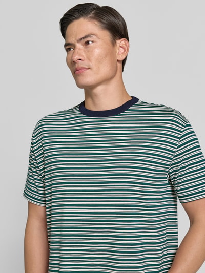Männermodel trägt Regular Fit T-Shirt mit Viskose-Anteil von MCNEAL, Streifen-Muster in Grün, Weiß, Blau, Nahaufnahme Oberkörper. Material-Mix mit Baumwoll- und Viskose-Anteil, Rundhalsausschnitt, kurzärmelig, Rückenlänge bei Größe M: 68 cm.