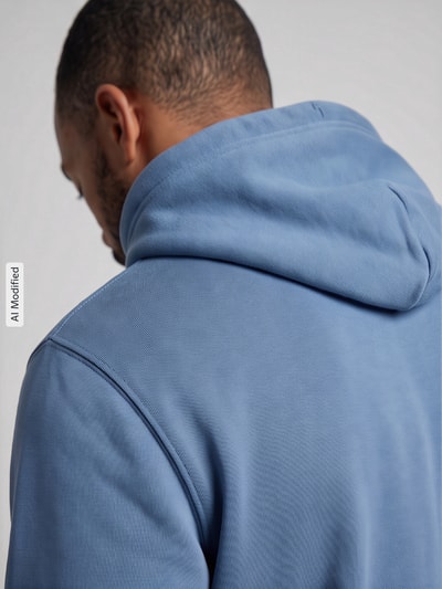 Männermodel trägt Regular Fit Hoodie aus Baumwoll-Mix von GANT in Hellblau, glatte Struktur, Ganzkörperansicht Rückansicht, KI-modifiziertes Bild.
