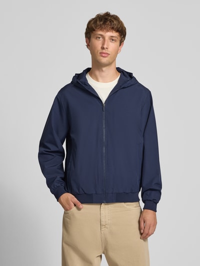 Männermodel trägt Regular Fit Jacke mit Kapuze Modell 'Charge' von JACK & JONES, dunkelblau, glatte Textur, Ganzkörperansicht von vorne. Damen Jacke, Kapuze, Reißverschluss, Rückenlänge 68 cm, Schulterbreite 50 cm, Brustweite 60 cm, Ärmellänge 66 cm.