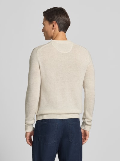 Männermodel trägt Slim Fit Strickpullover aus reiner Wolle mit Label-Stitching von MCNEAL, hellbeige Farbe, gerippte Abschlüsse, Rückenlänge 66 cm, Ärmellänge 69 cm, Ganzkörperansicht Rückansicht.