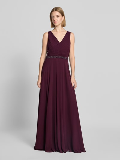 Frauenmodel trägt Fit and Flare Abendkleid mit Perlenstickerei von Vera Mont in dunklem Bordeaux, fließender Stoff, Ganzkörperansicht von vorne.