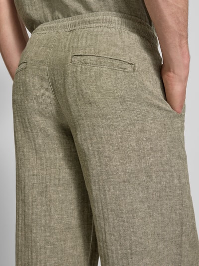 Männermodel trägt Hose aus Leinen-Baumwoll-Mix mit elastischem Bund von Redefined Rebel, Relaxed-Fit, Modell MAGNUS, Detailaufnahme Rückansicht.