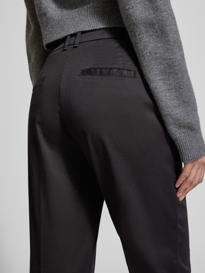 Männermodel trägt Straight Fit Stoffhose mit Lyocell-Anteil Modell 'Mara' von Brax, czarny kolor, szczegóły kieszeni, detailaufnahme tylnej części. Szerokość w rozmiarze 36: 39 cm, długość nogawki wewnętrznej: 68 cm, elastyczna mieszanka bawełny z lyocellem, krój straight fit, zapinanie na guzik i zamek, kieszenie boczne i tylne.