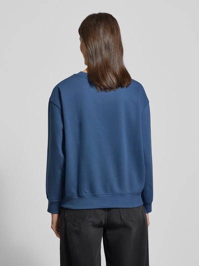 Frauenmodel trägt Regular Fit Sweatshirt aus Baumwoll-Mix von Tom Tailor Denim in Unifarbe Blau, gerippte Abschlüsse, Ganzkörperansicht Rückansicht.