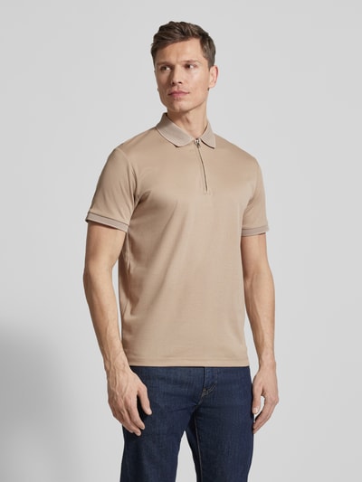 Männermodel trägt Regular Fit Poloshirt aus Bio-Baumwoll-Mix Modell 'FAVE' von SELECTED HOMME in Beige mit Strickkragen, Ganzkörperansicht von vorne.