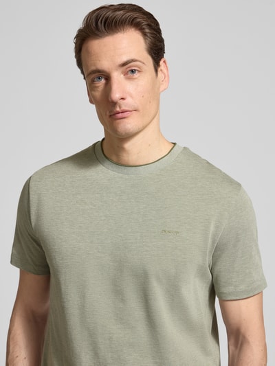Męski model nosi T-shirt mit Rundhalsausschnitt und Label-Stitching von Gant, bawełna, krój regular fit, okrągły dekolt, wyhaftowane logo, długość tyłu w rozmiarze M: 69 cm, zbliżenie na górną część ciała