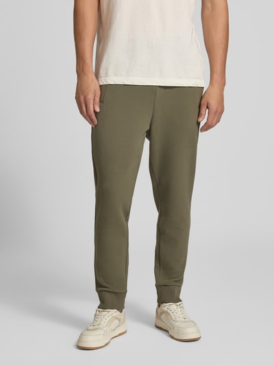 Männermodel trägt olivgrüne Regular Fit Sweathose aus Baumwoll-Mix Modell 'JT_Union Hadiko' von BOSS, strukturierte Oberfläche, Ganzkörperansicht von vorne, Herren Sweathose von BOSS.