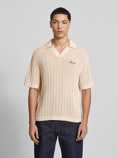 Mannenmodel draagt Slim Fit Poloshirt in Crochet-Optik van REVIEW, beige katoen, polokraag, korte mouwen, logo-stiksel, frontaal totaalbeeld