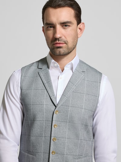 Męski model nosi Weste mit Reverskragen und Paspeltaschen od ATELIER TORINO, mieszanka bawełny, krój regular fit, zapięcie na guzik, kieszenie z wypustkami, długość tyłu w rozmiarze 50: 60 cm, szerokość ramion w rozmiarze 50: 40 cm, szerokość klatki piersiowej w rozmiarze 50: 50 cm, jasnoszara z delikatnym wzorem, gładka faktura. Zbliżenie na górną część ciała.