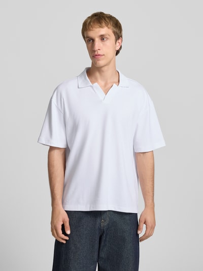 Männermodel trägt Boxy Fit Poloshirt aus Baumwoll-Mix Modell 'CASPIAN AIRLEX' von Only & Sons, weiß, kurzarm, unifarben, Ganzkörperansicht von vorne.