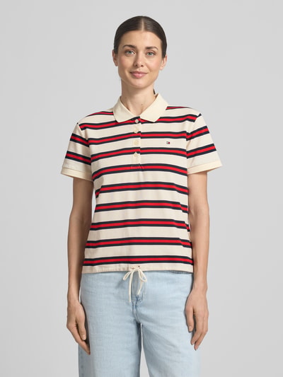 Frauenmodel trägt Regular Fit Poloshirt aus Baumwoll-Mix von Tommy Hilfiger, gestreift, mit Logo-Detail, Polokragen, Ganzkörperansicht von vorne.