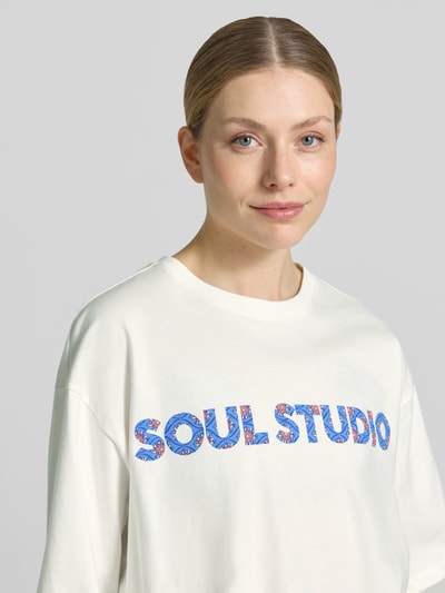 Vrouwenmodel draagt Cropped Boxy Fit T-Shirt met Label-Print van Smith and Soul in wit, katoen, ronde hals, labelprint, nahaufnahme bovenlichaam.