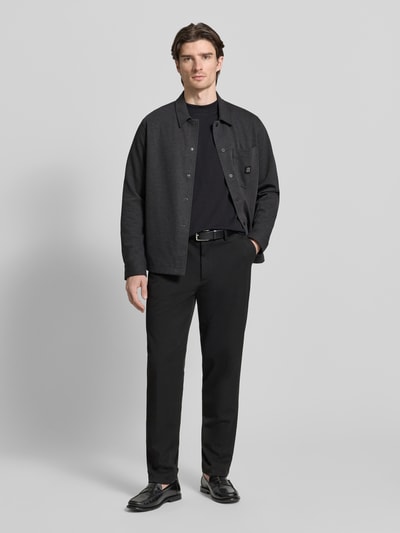 Männermodel trägt Oversized Hemdjacke aus Baumwoll-Mix Modell 'ENASO' von HUGO in dunklem Melange-Ton, Druckknöpfe, Twill-Struktur, Ganzkörperansicht von vorne.