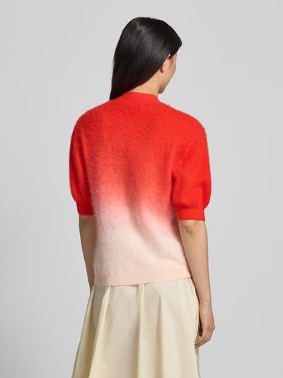 Frauenmodel trägt Strickpullover aus Kaschmir-Baumwoll-Mix mit Puffärmeln von HERZENS, Farbverlauf Rot zu Rosa, Regular-Fit, Stehkragen, 1/2-Arm, Rückenlänge 56 cm, Ärmellänge 26 cm, Ganzkörperansicht Rückansicht.