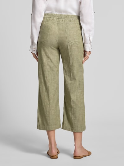 Frauenmodel trägt Culotte mit französischen Eingrifftaschen Modell 'Linn' von Angels aus Reine Baumwolle, Loose-Fit, elastischer Bund, grün, Struktur, Gesäßtaschen, Ganzkörperansicht Rückansicht.