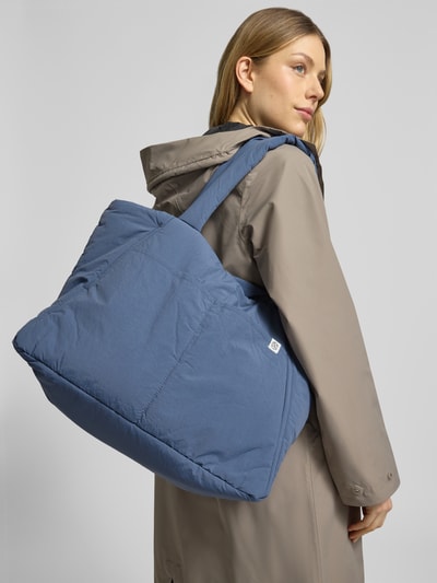 Frauenmodel trägt Shopper mit Label-Detail Modell 'SIRIA SASJA' von MSCH Copenhagen in Blau, wattierte Textur, Ganzkörperansicht Rückansicht.