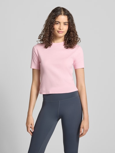 Modelka kobieca ma na sobie damski t-shirt z okrągłym dekoltem Topshop z bawełny, taliowany krój, krótki fason, długość tyłu w rozmiarze S 47 cm, jasnoróżowy, całkowity widok z przodu