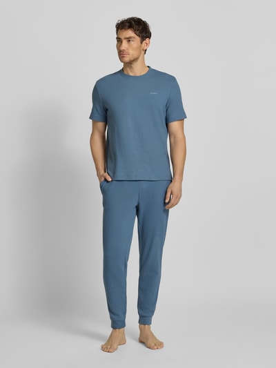 Männermodel trägt Regular Fit T-Shirt aus Baumwoll-Mix Modell 'AUSTIN' von HUGO in Unifarben mit Waffel-Struktur, Ganzkörperansicht von vorne.