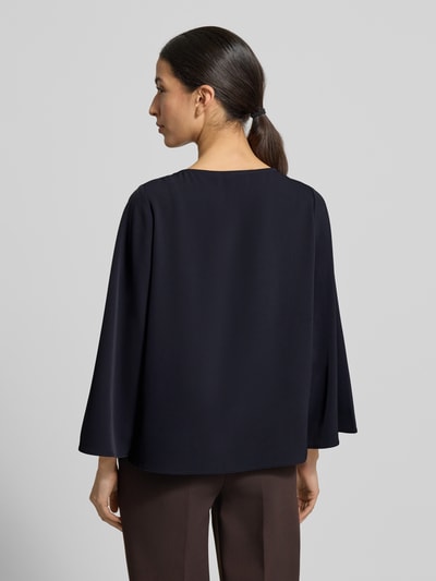 Modelka kobieca nosi Blusenshirt mit Rundhalsausschnitt od comma, czarny materiał z domieszką stretchu, luźny krój, długość pleców 59 cm, długość rękawa 52 cm, widok całej sylwetki z tyłu